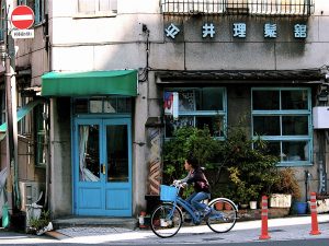 A woman riding a bicycle on the street during a Matsuyama tour.